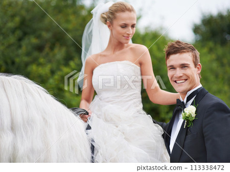 Couple, wedding and horse with nature, countryside and celebration for love, portrait and smile. Groom, wife and uk forest with happiness, marriage and horse riding for honeymoon, vacation or holiday 113338472
