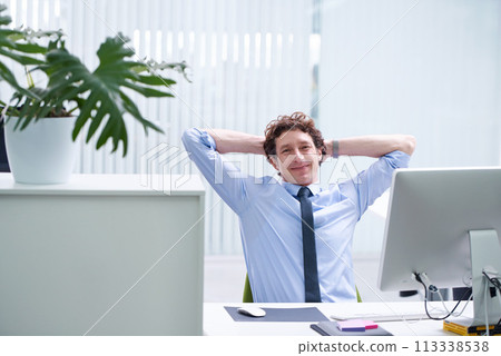 Man, office and relax portrait with computer, happy and confident corporate male person sitting and workspace desk. Technology, digital search administrator or smile, browse internet on business pc 113338538