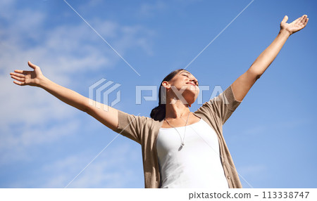 Smile, freedom and blue sky in summer with woman hands raised outdoor in fresh air of nature. Environment, happy or relax and young person satisfied with travel, vacation or holiday from below 113338747
