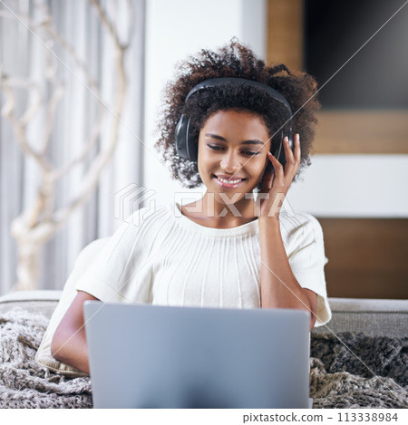 African, woman and smile with laptop, headphones and technology for video and music. Student, computer and internet for streaming, blog and email for connectivity and relaxation for wellness in house 113338984