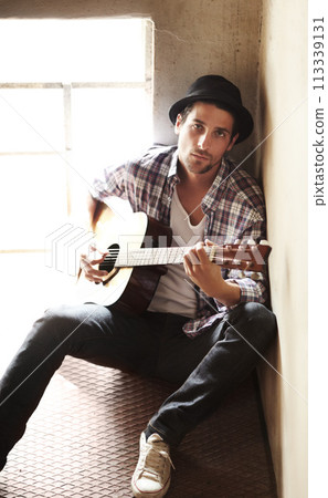 Guitar, portrait or artist in home for music, performance or entertainment with sound, rhythm or talent. Learning solo, man or creative musician playing an instrument for artistic expression alone 113339131