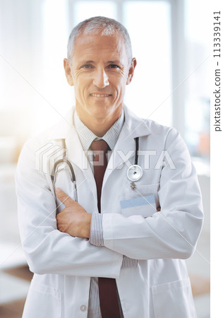 Healthcare, portrait and doctor with arms crossed in hospital for support, services and wellness. Medicine, lens flare and happy mature medical professional for confident, help and treatment 113339141