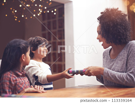 Mom, children and happy in table with gift as birthday present with smile, support and bonding. Home, family and excited together in living room for childhood memories, care for love and siblings Mom, children and happy in table with gift as birthday present with smile, support and bonding. Home, family and excited together in living room for childhood memories, care for love and siblings 113339164