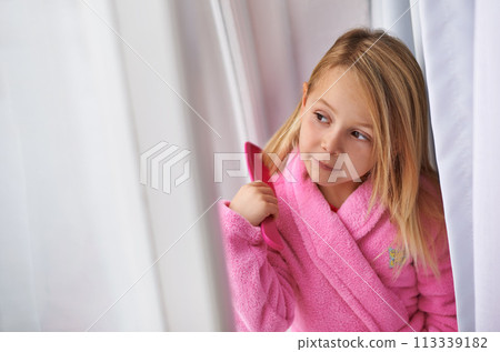 Child, hair and brush for morning routine in bathrobe for beauty grooming for getting ready, treatment or cosmetic. Girl, kid and comb in home apartment in London for style care, healthy or texture 113339182
