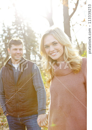 Enjoying a walk in the Fall woods. An affectionate and romantic young couple spending time together in the woods. 113339253