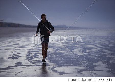 Running, beach and man with fitness travel and exercise with wellness, explore and ocean. Person, runner and guy with fun, water and sunset with break and breathing with workout, energy and Miami 113339313