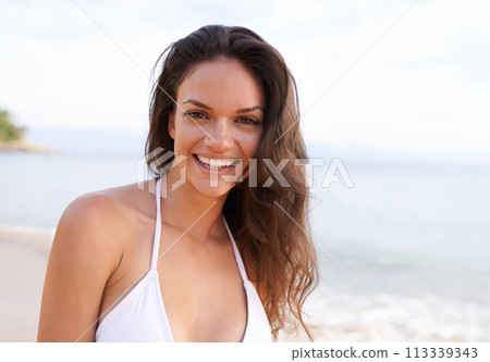 Beach, nature and portrait of woman for travel on tropical vacation, adventure or holiday. Happy, smile and female person with positive attitude by ocean on outdoor summer weekend trip by island. 113339343