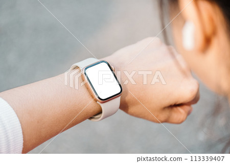 Close-up of a person wrist wearing a modern smartwatch with a blank screen, indicating connectivity and technology in everyday life. Close-up of a person wrist wearing a modern smartwatch with a blank screen, indicating connectivity and technology in everyday life. 113339407