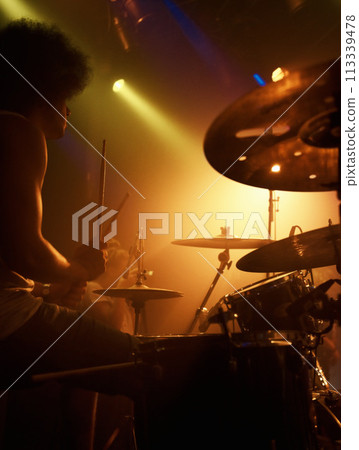 Stage, drummer and man in performance at concert playing jazz, beat and talent for music. Drums, musician and person in theater spotlight with instrument for percussion, rhythm and show at night Stage, drummer and man in performance at concert playing jazz, beat and talent for music. Drums, musician and person in theater spotlight with instrument for percussion, rhythm and show at night 113339478