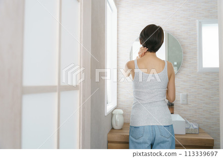 Back view of a woman getting ready in the bathroom in the morning 113339697