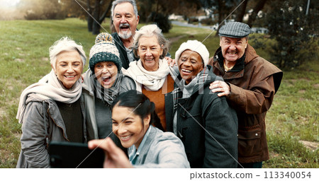 Nature, selfie and senior friends with woman while walking in outdoor garden for fresh air. Diversity, happy and group of elderly people in retirement taking picture with young female person in park. 113340054