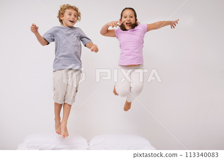 Jumping, bed and kids with fun, energy and morning in a bedroom with game and sibling. Youth, hop and home with a excited children on a duvet in air with crazy play and leap in house with friends 113340083
