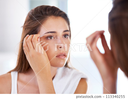 Woman, mirror and eyebrows with tweezers for beauty routine in bathroom for skincare, maintenance or cosmetic. Female person, hand and tool with morning reflection for hair removal, treatment or care Woman, mirror and eyebrows with tweezers for beauty routine in bathroom for skincare, maintenance or cosmetic. Female person, hand and tool with morning reflection for hair removal, treatment or care 113340255