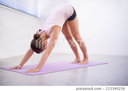 Yoga, downward dog and woman with body stretching for fitness, natural exercise and balance in home. Workout, pilates and healthy girl on mat for morning muscle warm up, wellness or self care mission 113340256