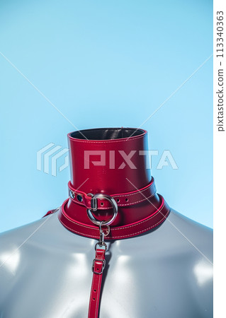 A red leather strap is tied around a mannequin's neck 113340363