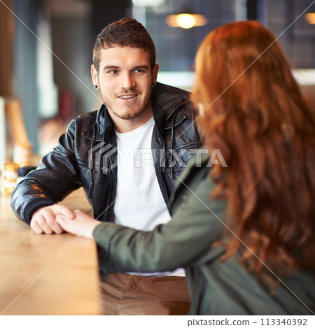 Couple, hand holding and conversation in restaurant, romance and affection on date. Valentines day, sitting together with love for bonding, female person with boyfriend for trust and compassion 113340392
