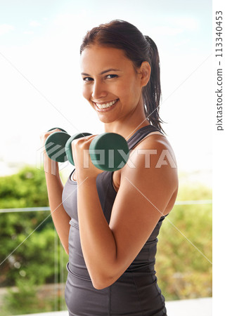 Portrait, dumbbell and happy woman outdoor for training, exercise and workout for power. Face, muscle and strong person weightlifting for fitness, sports and healthy body for wellness at balcony 113340453