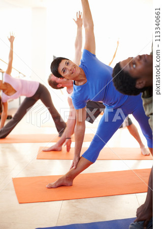 Yoga, stretching and portrait of woman in trikonasana pose at gym, exercise or healthy body, wellness or pilates. Fitness, happy group and triangle, balance flexibility and practice in class together Yoga, stretching and portrait of woman in trikonasana pose at gym, exercise or healthy body, wellness or pilates. Fitness, happy group and triangle, balance flexibility and practice in class together 113340661
