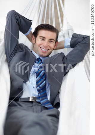 Portrait, hammock and man with business, relax and smile with confidence, break and vacation. Person, employee and entrepreneur with achievement, consultant and calm with peace, startup and happy 113340700