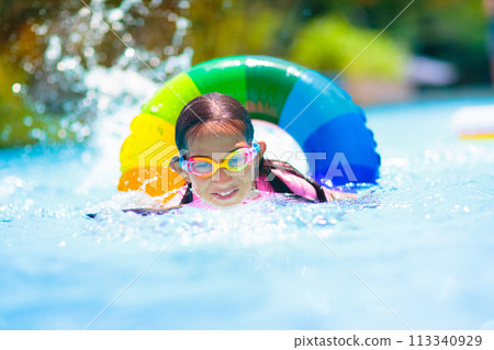 Child in swimming pool on toy ring. Kids swim. Child in swimming pool on toy ring. Kids swim. 113340929