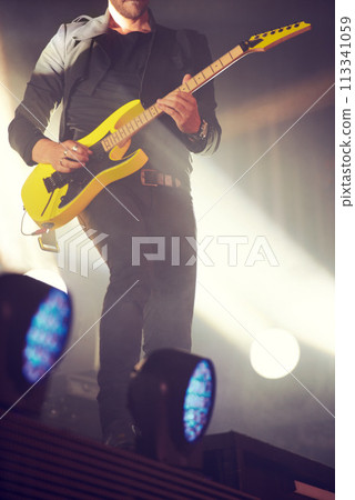 Man, stage and guitar for performance at concert, music festival or live event in Amsterdam. Male artist, electric instrument and playing on stage for crowd, people or audience with enjoyment 113341059