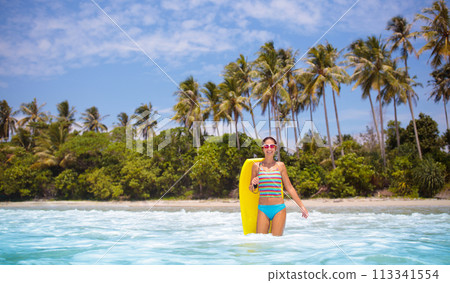 Young woman with surf board on tropical beach Young woman with surf board on tropical beach 113341554