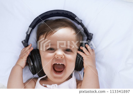 Baby, headphones and music in portrait and singing, streaming radio and podcast on bed at home. Girl, relax and hearing audio for child development or learning, toddler and fun playlist for kid Baby, headphones and music in portrait and singing, streaming radio and podcast on bed at home. Girl, relax and hearing audio for child development or learning, toddler and fun playlist for kid 113341897