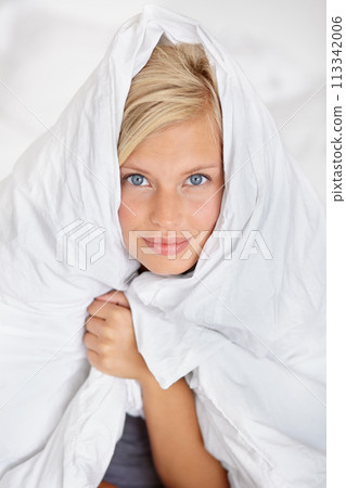 Bed, portrait and blanket to cover woman in morning or home with warm sheet on body. Cosy, girl and duvet on head of person to wake up on holiday or vacation wrapped in linen for comfort in bedroom 113342006