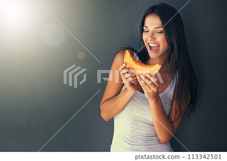 Slice of melon, happy and woman with nutrition, wellness and lens flare on a grey background. Person, mockup space and model with a fruit and excited with diet plan and healthy living with vegetarian 113342501