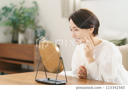 一個女人在客廳看著鏡子微笑 113342565