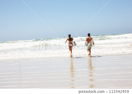 Couple, beach and surfboard for surfing or rear view with waves, adventure and fitness with blue sky. Tourist, people and surfer by ocean in morning for holiday, vacation and freedom in California Couple, beach and surfboard for surfing or rear view with waves, adventure and fitness with blue sky. Tourist, people and surfer by ocean in morning for holiday, vacation and freedom in California 113342959