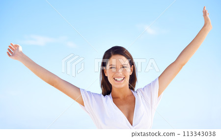 Blue sky, portrait and woman on holiday with freedom, happy adventure and sunshine in Greece. Summer, smile and face of girl stretching arms for energy, wellness and outdoor travel vacation in nature 113343038