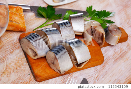 Slices of lightly salted mackerel fish served with greens 113343109