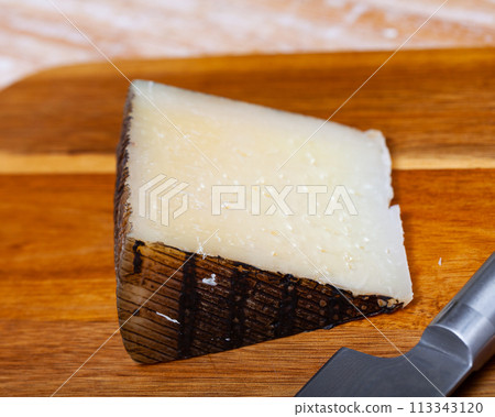 Spanish tasty sheep cheese Manchego on wooden surface Spanish tasty sheep cheese Manchego on wooden surface 113343120