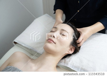 A woman receiving head spa treatment 113343510