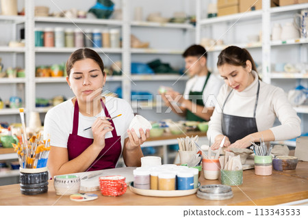 Two young women making pottery in workshop Two young women making pottery in workshop 113343533