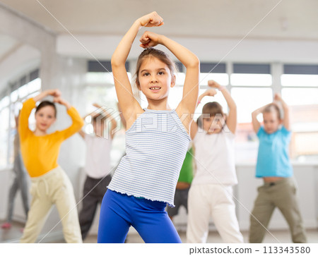 Girl learn to dance hip hop dances, doing movement with unrecognizable teacher. Girl learn to dance hip hop dances, doing movement with unrecognizable teacher. 113343580