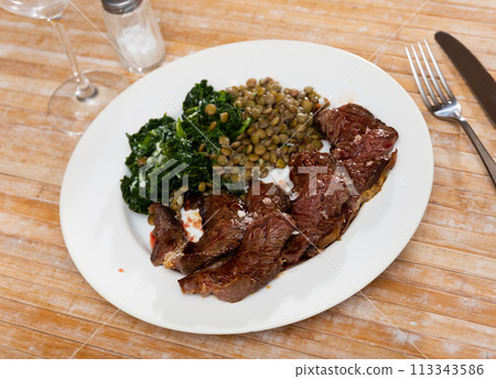 Grilled veal tenderloin with stewed lentils and spinach Grilled veal tenderloin with stewed lentils and spinach 113343586