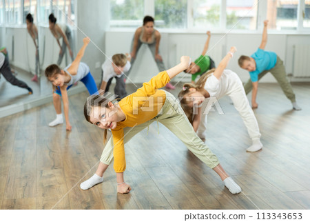 Girl learn to dance hip hop dances, doing movement with unrecognizable teacher. Girl learn to dance hip hop dances, doing movement with unrecognizable teacher. 113343653