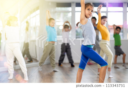 Girl learn to dance modern dances, doing movement with unrecognizable teacher. Girl learn to dance modern dances, doing movement with unrecognizable teacher. 113343731