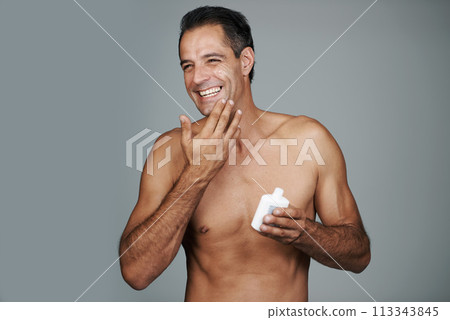 Man, smile and moisturizer lotion in studio for skincare treatment for facial wellness, grey background or mockup space. Male person, product and healthy dermatology for anti aging, cream or apply Man, smile and moisturizer lotion in studio for skincare treatment for facial wellness, grey background or mockup space. Male person, product and healthy dermatology for anti aging, cream or apply 113343845