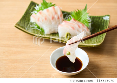 Sea bream sashimi dipped in soy sauce Sea bream sashimi dipped in soy sauce 113343970