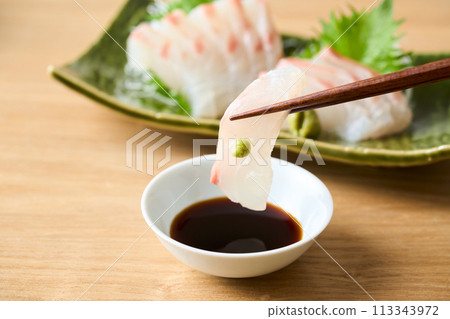 Sea bream sashimi dipped in soy sauce Sea bream sashimi dipped in soy sauce 113343972