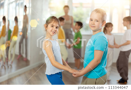 Happy preteen children practicing ballroom dances in pairs in training hall 113344047