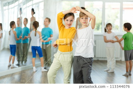 Happy preteen children practicing ballroom dances in pairs in training hall 113344076