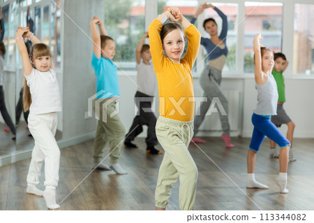 Girl learn to dance modern dances, doing movement with unrecognizable teacher. 113344082