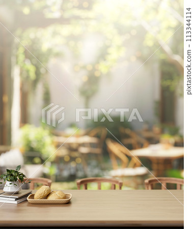 An outdoor wooden dining table in a beautiful restaurant or coffee shop garden. An outdoor wooden dining table in a beautiful restaurant or coffee shop garden. 113344114