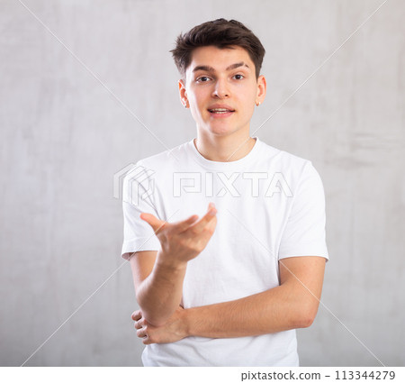 Emotions, people and positive concept - young man expresses various on gray background Emotions, people and positive concept - young man expresses various on gray background 113344279