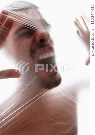 Male person, plastic and bag with choking, gasping and struggle for air in white background. Man, expression and suffocating in crisis for awareness, help and anxiety in mental health or wellness 113344436