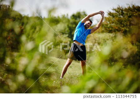Man, stretching and nature for warm up and exercise for fitness, body health and physical training. Male person or athlete and workout for cardio, active strength or healthy recreation outside 113344755
